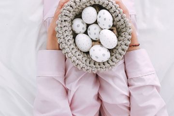 Femme sur un lit tenant panier d'oeufs